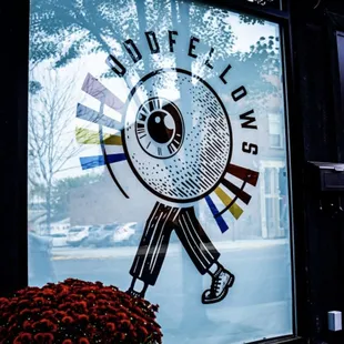 a man holding a baseball bat in front of a window