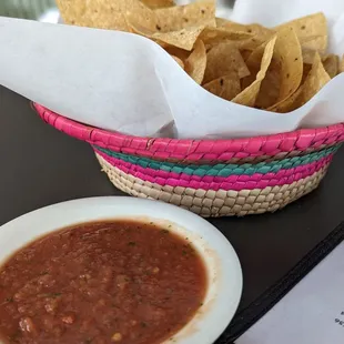 a plate of chips and a bowl of salsa
