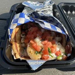 a hot dog with tomatoes and onions