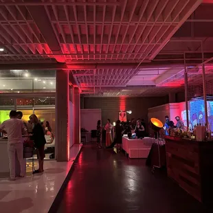 people standing in a room with red lighting
