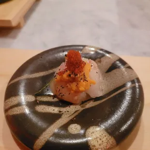a scallop dish on a black plate