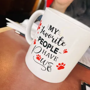 a woman sitting at a table with a coffee mug