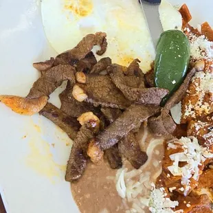 Look at the meat .  Large pieces of fat.    Chilaquiles where crunchy like chips.   They are supposed to be soft.     Worse place ever
