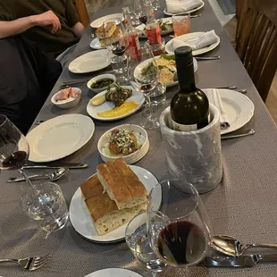 a long table with plates of food and glasses of wine
