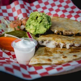 a quesadilla with a side of guacamole