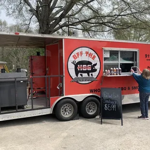 a woman standing in front of a food truck