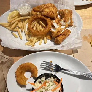 Fish and chips , fries and onion rings and coleslaw