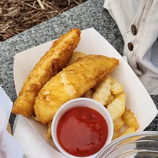 a basket of fish sticks with ketchup