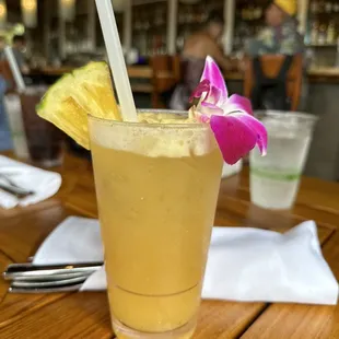 a drink with a purple flower in it