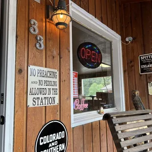 a wooden building with a sign and a window
