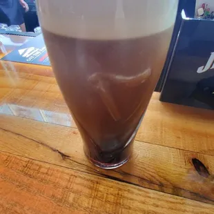 a glass of coffee on a wooden table