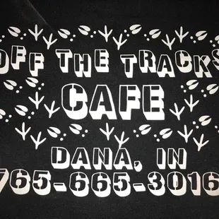 a black t - shirt with the words off the tracks cafe on it