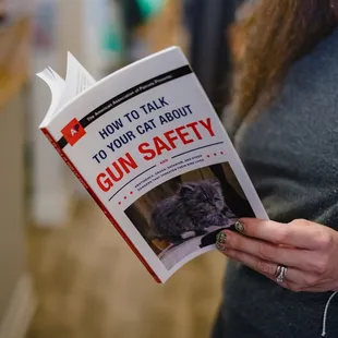 a woman reading a book about gun safety