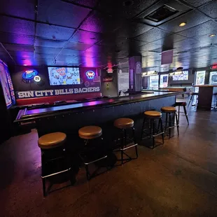 a row of stools in front of the bar