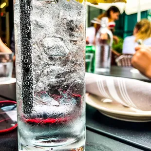 a glass of water with ice and a lemon slice
