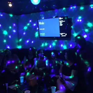 a group of people sitting in a room with disco lights