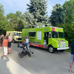 a group of people standing outside of a food truck