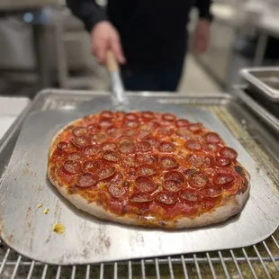 a person preparing a pizza