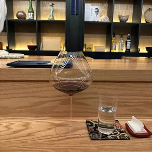 a glass of wine and chopsticks