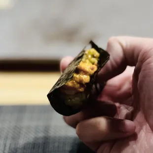 a hand holding a sushi