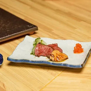 a plate of sushi and a spoon