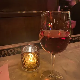 a glass of wine and a candle