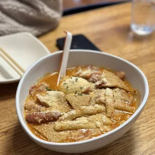 a bowl of soup with chopsticks