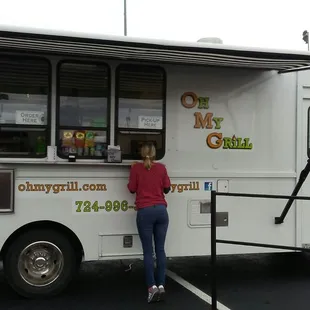 a woman ordering food from a food truck