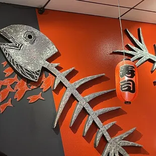 a fish and a lantern hanging on a wall