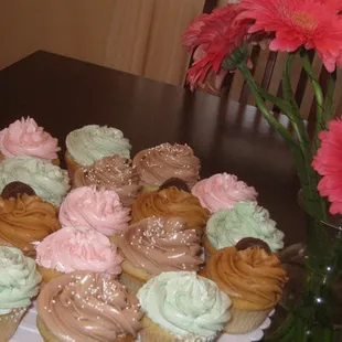 a plate of cupcakes and flowers