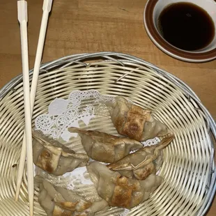 a bowl of dumplings and chopsticks
