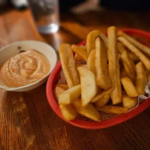 a bowl of french fries and a bowl of dip