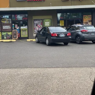 two cars parked in front of a store