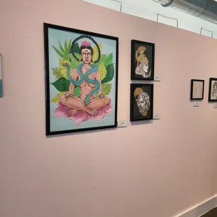 a pink wall with paintings on it