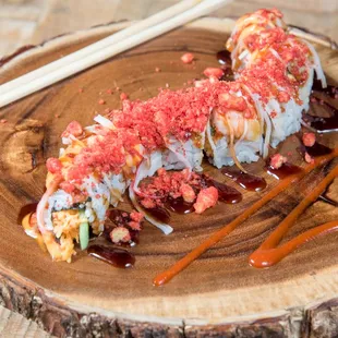 a plate of sushi with chopsticks