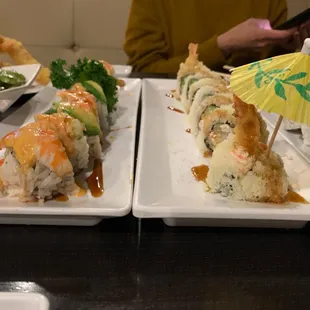 two plates of sushi with a parasol