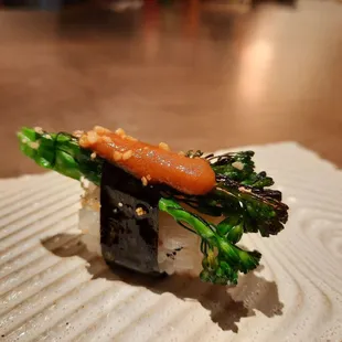 a piece of sushi with broccoli