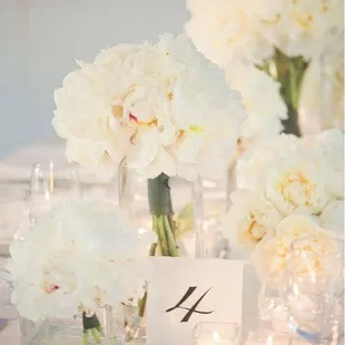 a table setting with white flowers and candles