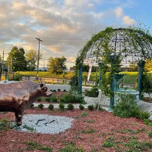 a statue of a bull in a garden