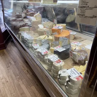 a variety of cheeses in a display case