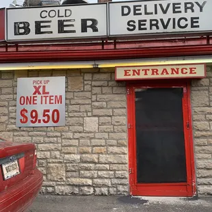 a red car parked in front of a brick building