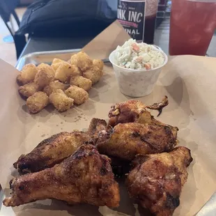 Smoked Bone-in Wings tossed in their dry rub, tots and their slaw. Rum Runner Cocktail in the background.