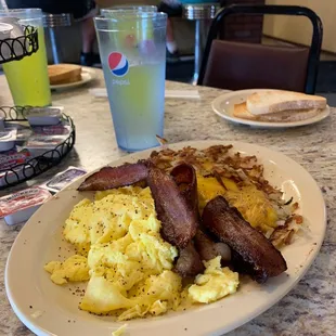 a breakfast of eggs, bacon and hash browns