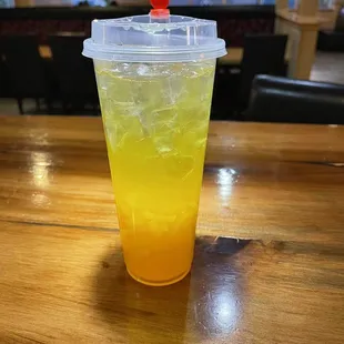 a drink in a plastic cup on a wooden table