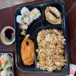 a bento box with rice, chicken, and vegetables