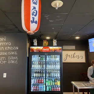 a woman sitting at a table in front of a vending machine