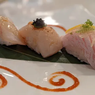  three pieces of sushi on a leaf