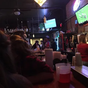 people sitting at a bar watching television