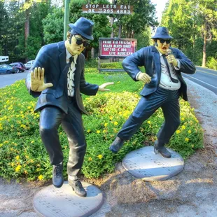 two statues of men in suits and hats