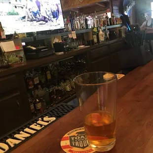 a glass of whiskey sitting on a bar